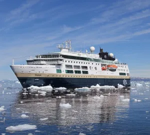 HX Expeditions ship in Indigo Blue and Sand sailing through icy waters