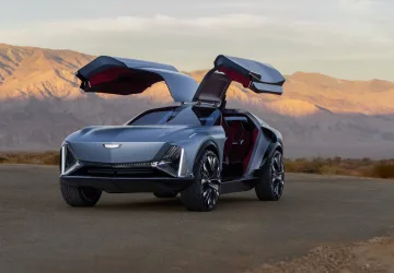 Front 3/4 view of the Cadillac Elevated Velocity concept in Vapor Blue with the gull-wing doors open with the desert in the background.