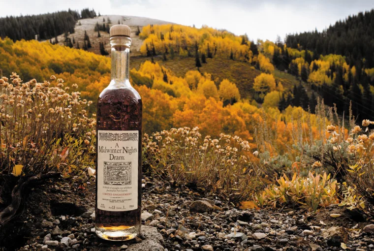 High West A Midwinter Night’s Dram Act 13 bottle and glass of whiskey displayed with fall and winter accents
