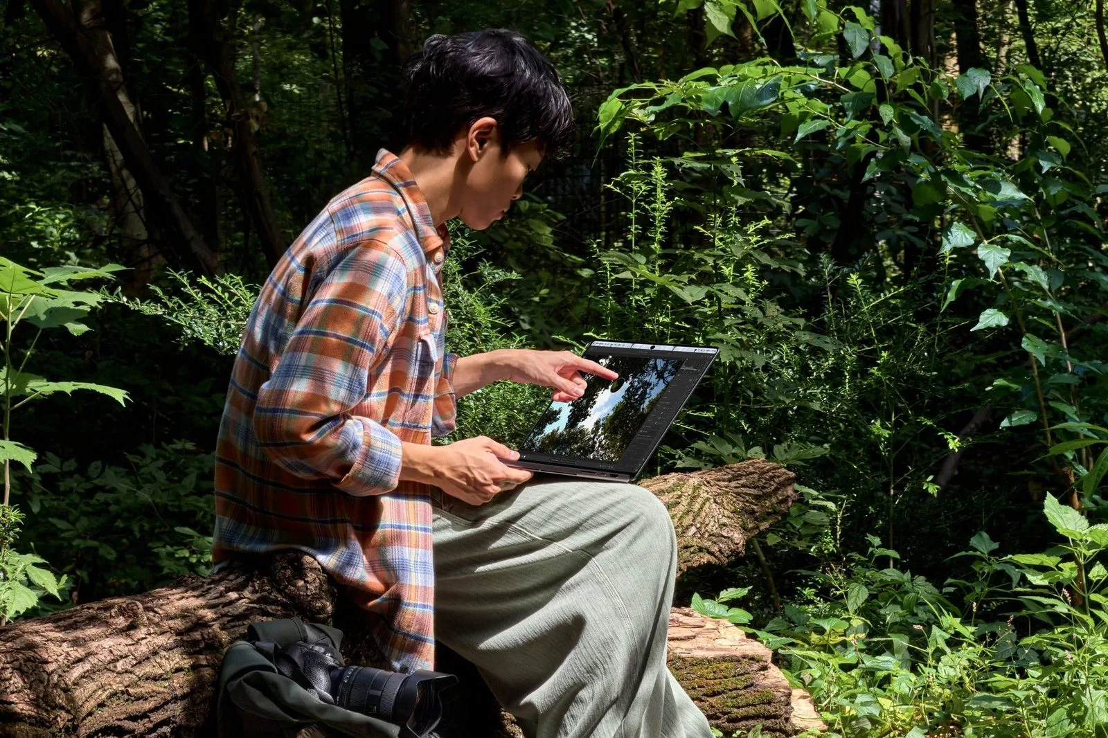 Person using a MacBook Pro with PROLED XDR Display outdoors in bright light