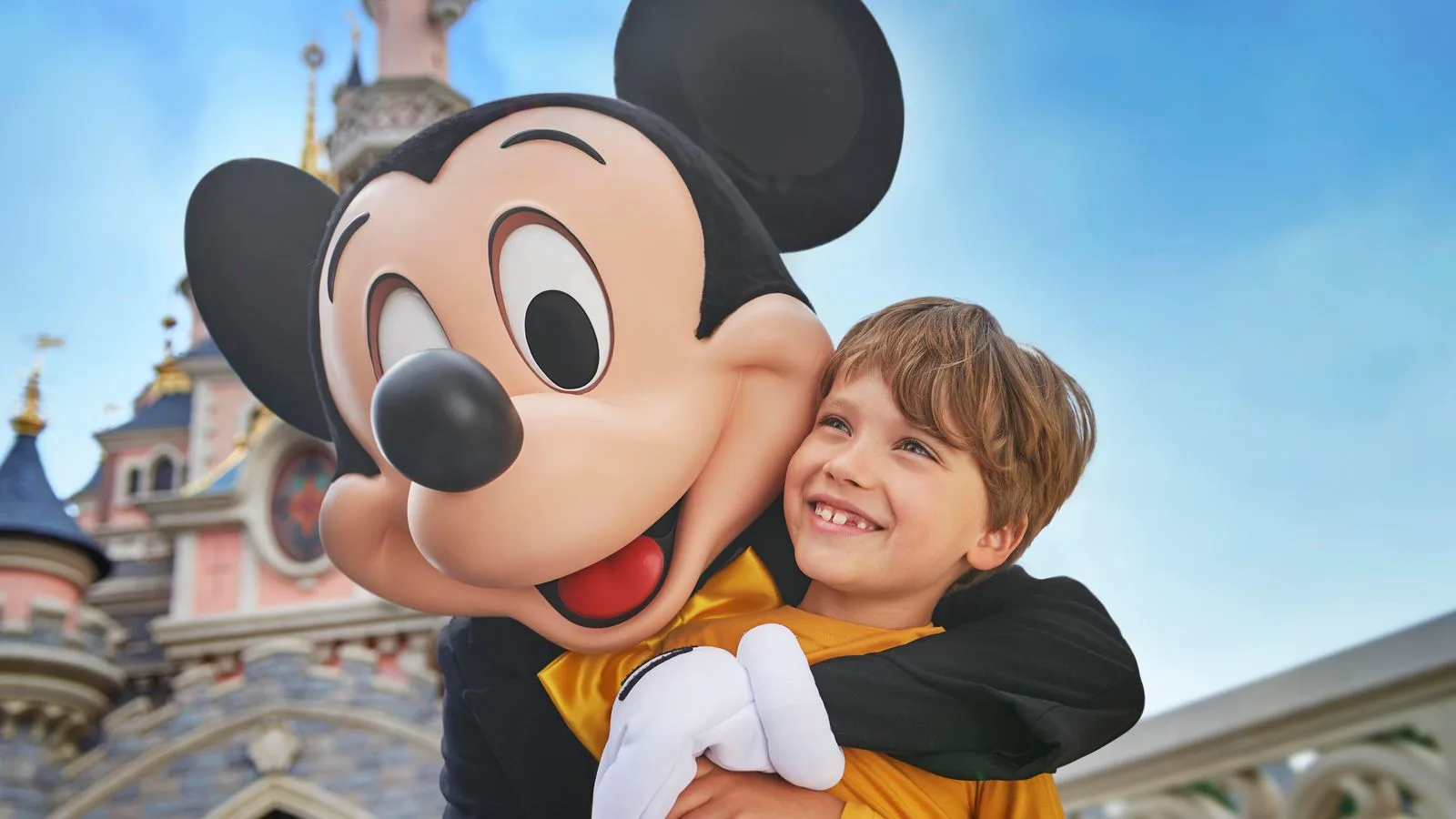 Mickey Mouse hugging a child at Disneyland Paris