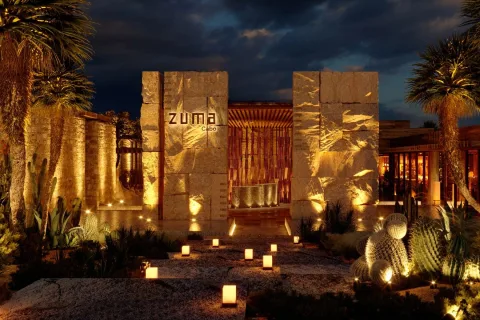 Zuma Cabo restaurant entrance at night with illuminated stone walls and ZUMA Cabo signage
